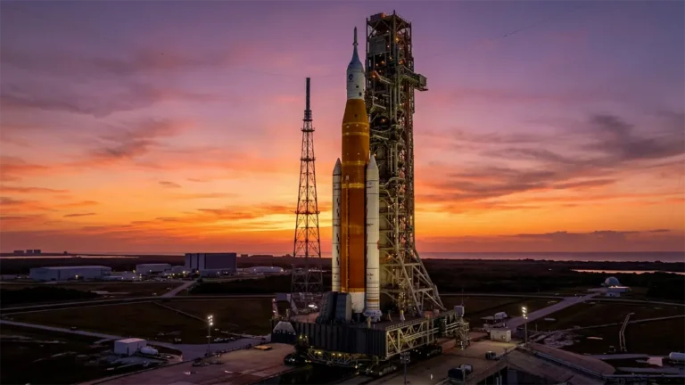 The NASA Space Launch System (SLS) rocket stands on the launch pad at sunset, prepared for the Artemis II crewed mission.