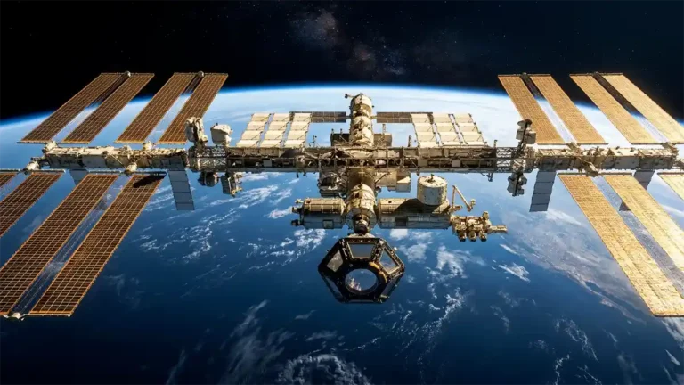 The International Space Station Over Earth 2026.Wide shot of the International Space Station with solar arrays extended against the curvature of Earth.